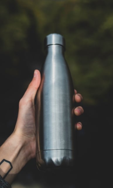 hand holding stainless steel water bottle