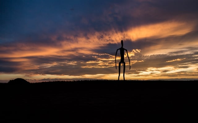 alien silhouette in front of sunset