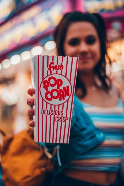 smiling woman holding a box of popcorn