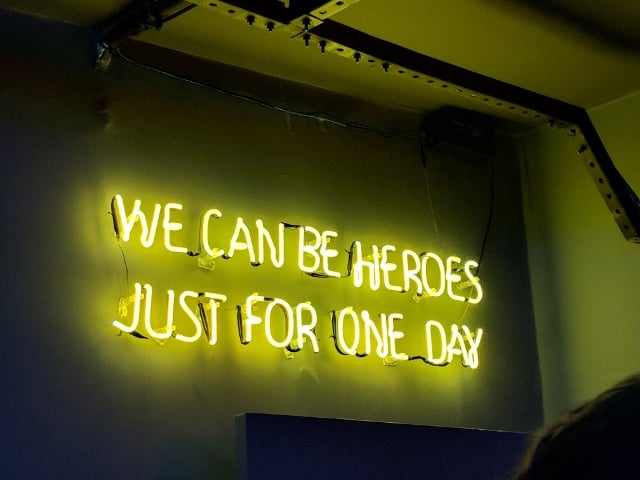 neon sign that says 'we can be heroes just for one day'