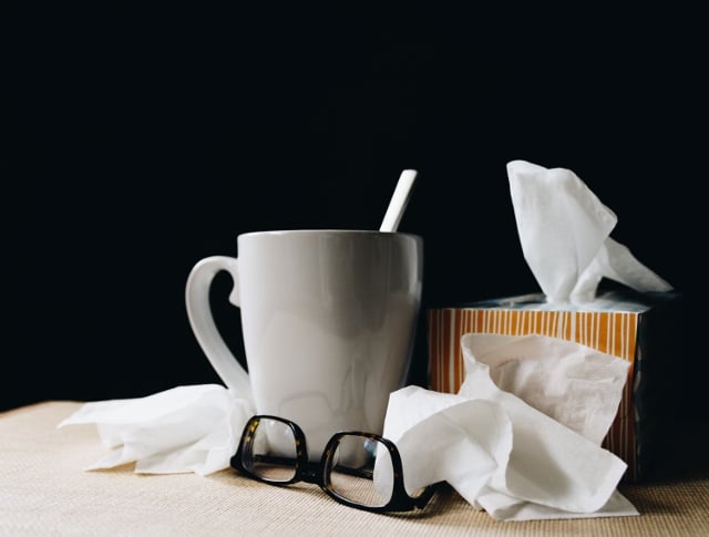 cup of tea, tissues, and glasses for a sick day