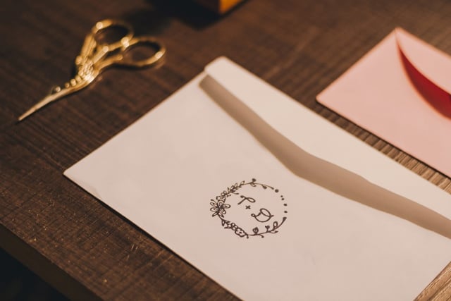 monogrammed envelope and small scissors on table