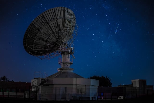 large satellite dish against night sky