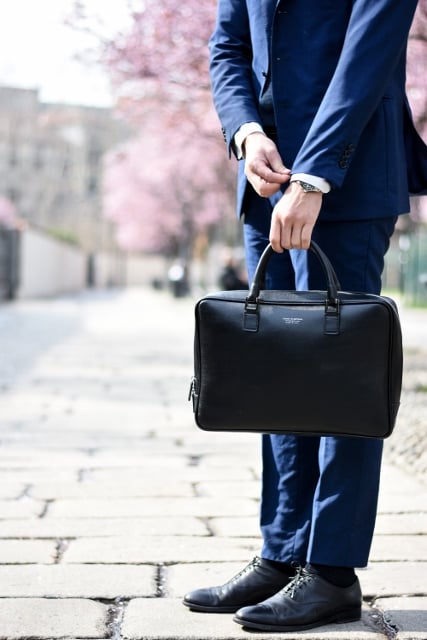 salesman holding briefcase and wearing blue suit