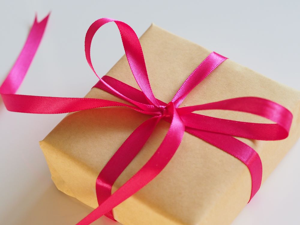 brown box wrapped up with pink ribbon bow