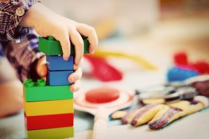 child's hands stacking blocks