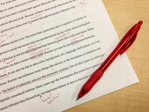 red pen laying on edited paper removing unnecessary words