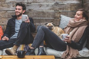 young male and female hanging out outdoors with pug