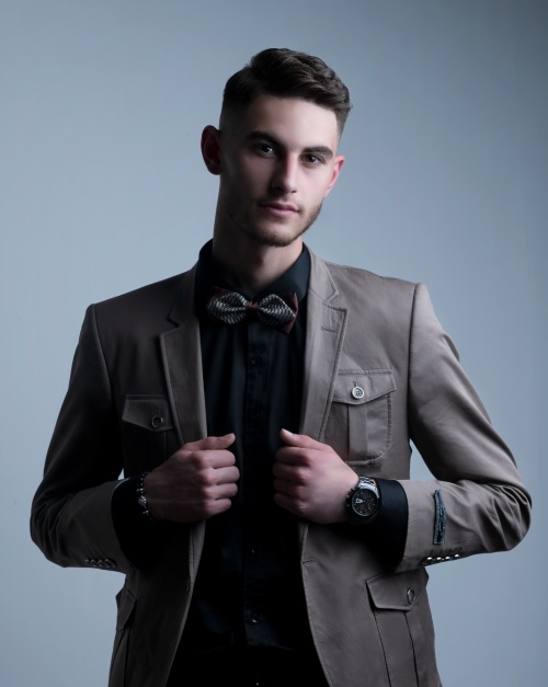 dapper young man facing camera wearing bow tie and jacket