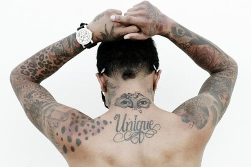 person with the word unique tattooed on upper back