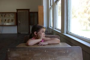 hungry young student staring out classroom window