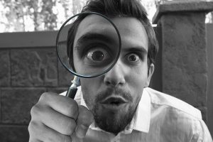 man looking for examples with magnifying glass