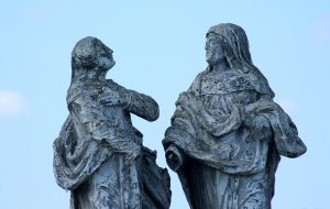 weathered historical statues facing one another