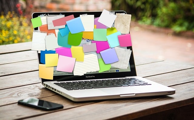 laptop covered in paper sticky notes